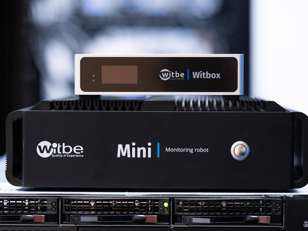 Witbe monitoring robots showing the older Witbox Mini and the newer Witbox model for real-device video testing and QoE measurement.