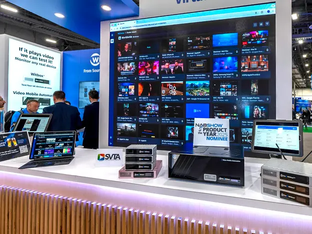 Witbe trade show booth showcasing Witbox devices and real-device video monitoring on a large screen.